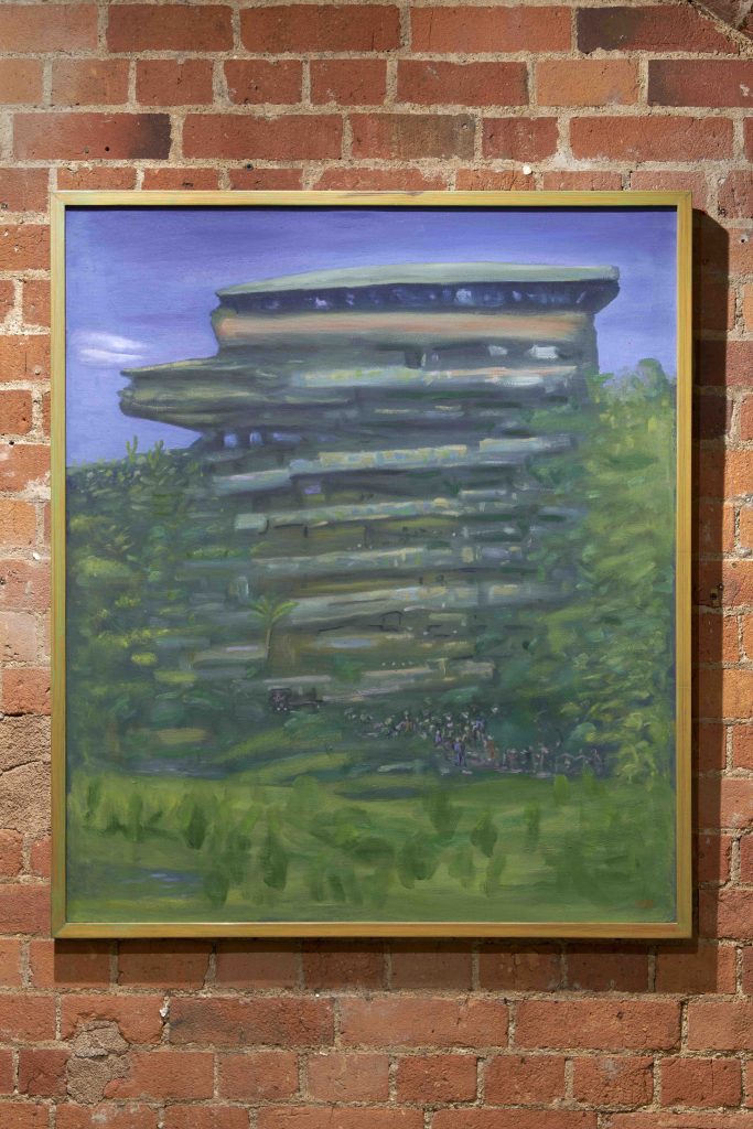 A painting of a futuristic structure in a natural environment hanging on a brick wall.